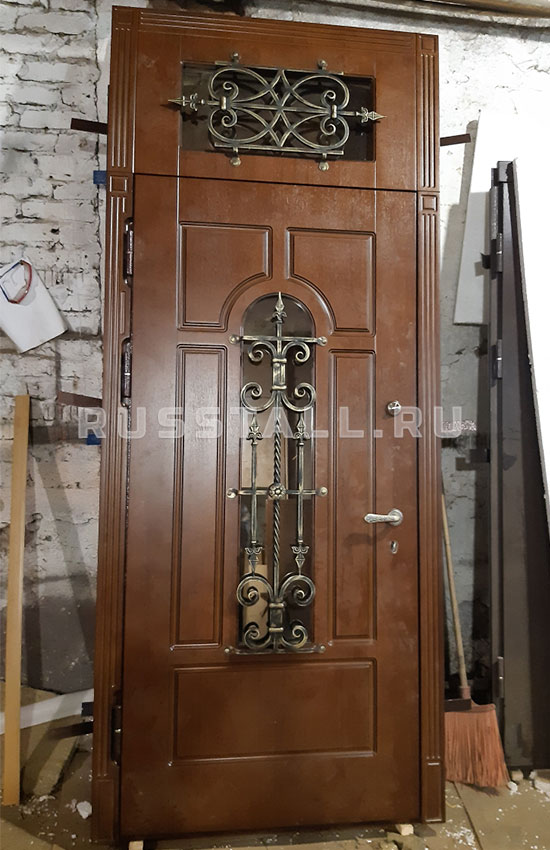 Железная дверь в коттедж с фрамугой — изображение